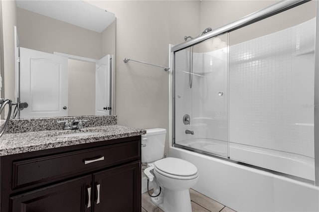 full bathroom with toilet, bath / shower combo with glass door, vanity, and tile patterned flooring