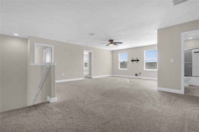 carpeted spare room featuring ceiling fan