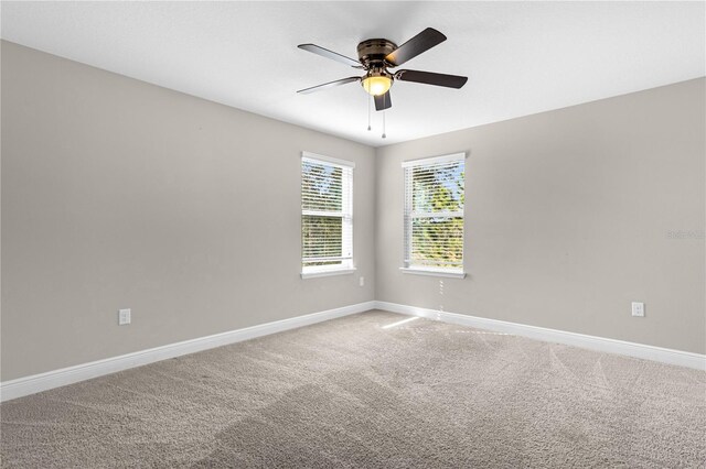 carpeted spare room with ceiling fan