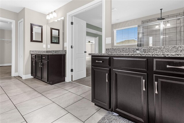 bathroom with vanity, a shower with shower door, and tile patterned flooring