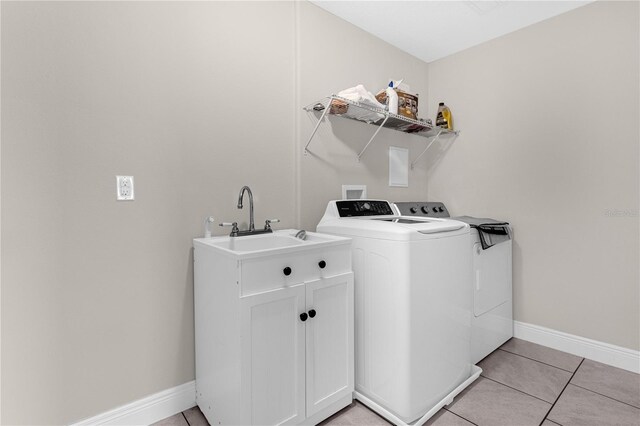 laundry area featuring sink, washer and dryer, and light tile patterned floors