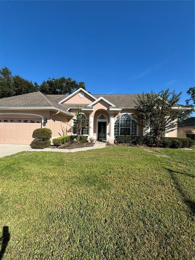 ranch-style home featuring a garage and a front lawn