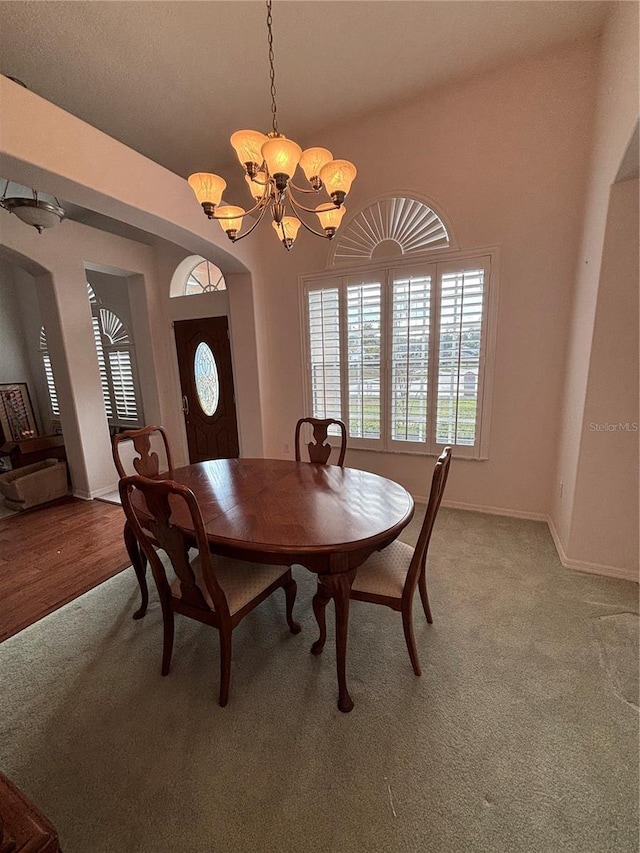 carpeted dining room with an inviting chandelier