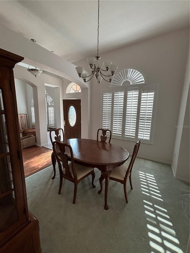 carpeted dining space featuring an inviting chandelier