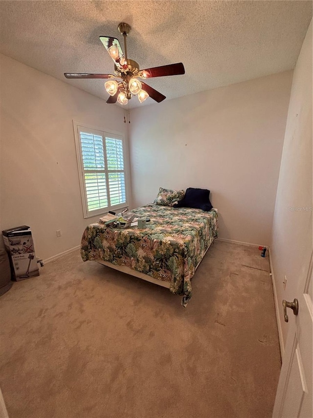 bedroom featuring ceiling fan, carpet floors, and a textured ceiling