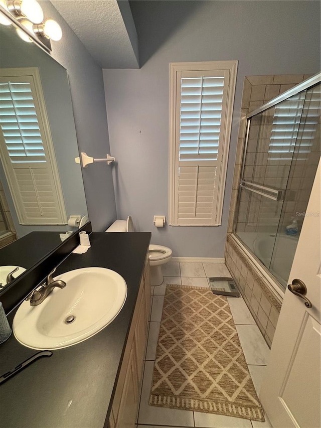 full bathroom with vanity, tile patterned floors, toilet, enclosed tub / shower combo, and a textured ceiling