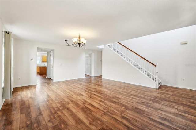 unfurnished living room featuring hardwood / wood-style flooring and an inviting chandelier