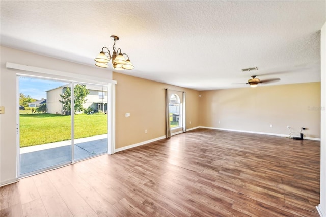 empty room featuring hardwood / wood-style floors, a textured ceiling, and ceiling fan with notable chandelier