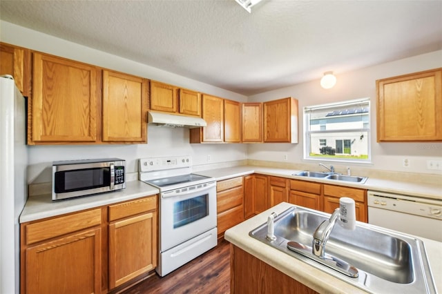 kitchen with white appliances, a textured ceiling, sink, and dark hardwood / wood-style flooring