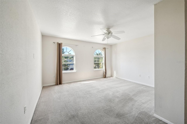 empty room with light carpet, a textured ceiling, and ceiling fan