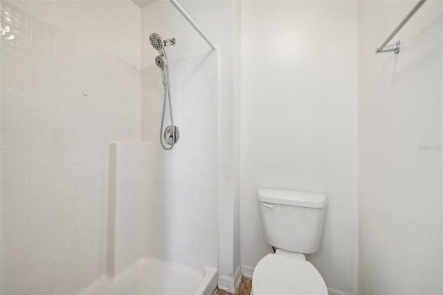 bathroom with tiled shower and toilet