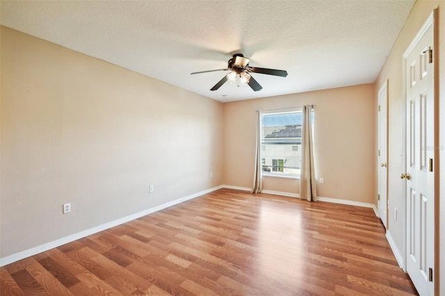 empty room with light hardwood / wood-style floors, a textured ceiling, and ceiling fan