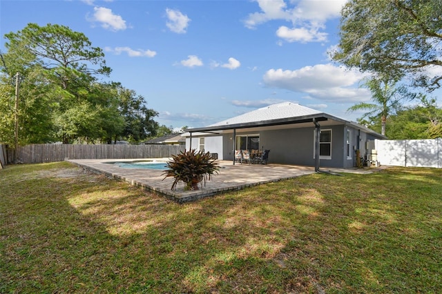 rear view of house with a patio area, a fenced in pool, and a yard