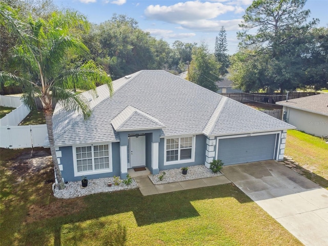 ranch-style house featuring a front yard and a garage