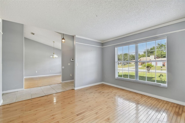 spare room with plenty of natural light, light wood-type flooring, and a textured ceiling