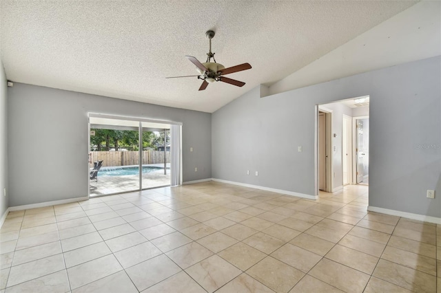 tiled empty room featuring a textured ceiling, ceiling fan, and lofted ceiling