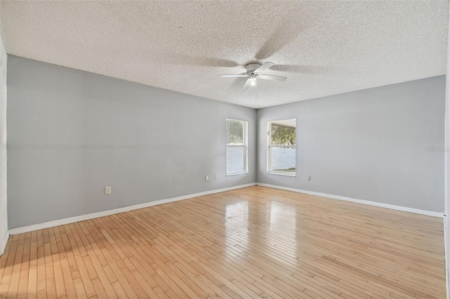 empty room featuring ceiling fan, light hardwood / wood-style floors, and a textured ceiling