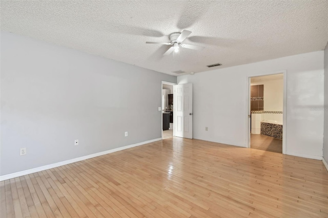 unfurnished room with a textured ceiling, light wood-type flooring, and ceiling fan