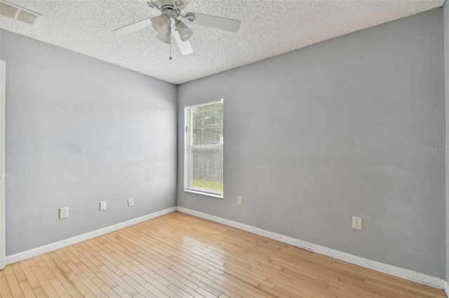 empty room with ceiling fan, light hardwood / wood-style floors, and a textured ceiling