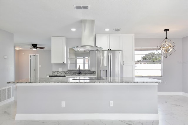 kitchen featuring white cabinetry, light stone countertops, island range hood, and a kitchen island