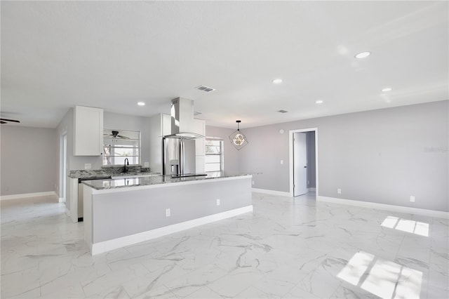 kitchen featuring a kitchen island, extractor fan, stainless steel refrigerator with ice dispenser, hanging light fixtures, and white cabinets