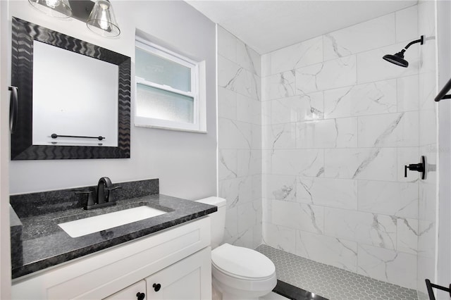 bathroom featuring vanity, toilet, and tiled shower