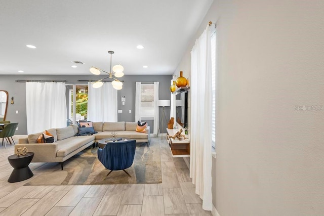 living room with a chandelier and light wood-type flooring