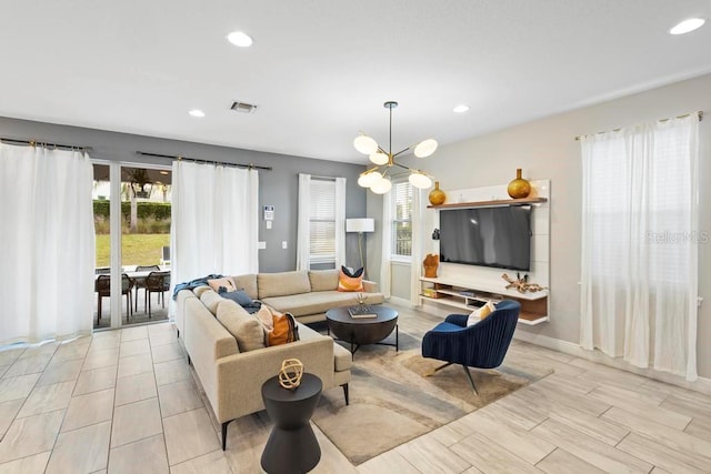 living room with an inviting chandelier and light wood-type flooring