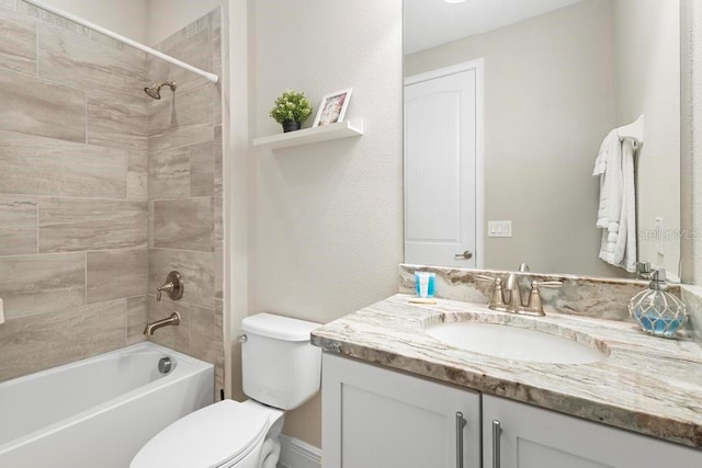 full bathroom featuring tiled shower / bath, vanity, and toilet