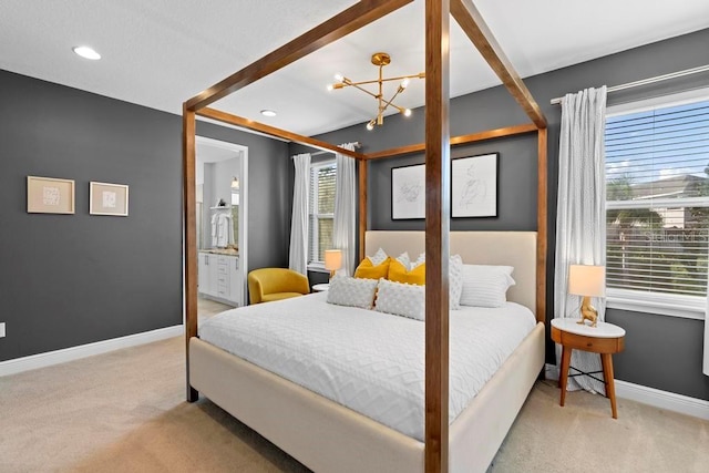 carpeted bedroom with multiple windows, ensuite bath, and a notable chandelier