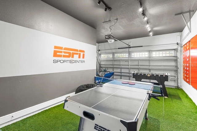 recreation room featuring dark colored carpet, a wealth of natural light, and rail lighting