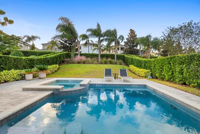 view of pool featuring a yard, a patio area, and an in ground hot tub