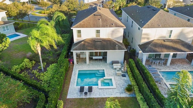 rear view of house with exterior bar, a patio, and a fenced in pool