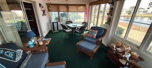 sunroom / solarium with a water view and a healthy amount of sunlight