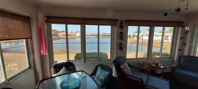 sunroom featuring a water view