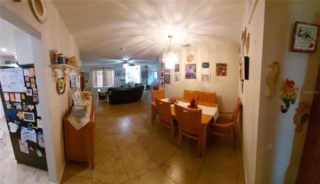 dining space featuring ceiling fan with notable chandelier