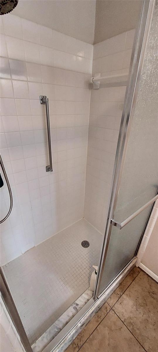 906 Bluewater Dr, Sun City Center, FL 33573 - bathroom with a shower stall and tile patterned flooring