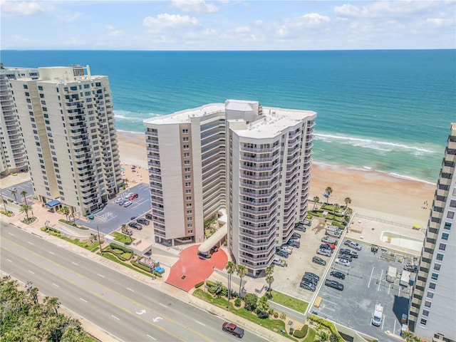 birds eye view of property with a water view and a beach view