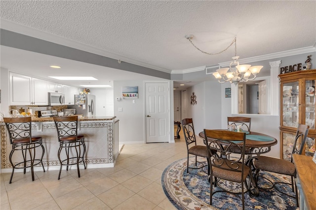 tiled dining room featuring crown molding, a textured ceiling, and an inviting chandelier