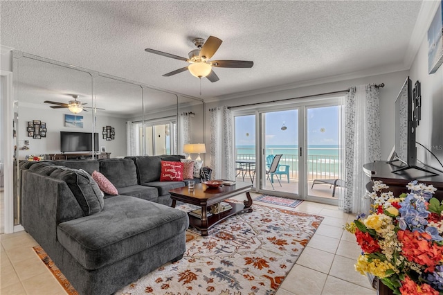 tiled living room with ceiling fan, crown molding, and a textured ceiling