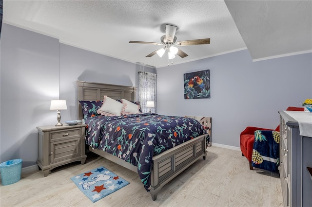 bedroom with ceiling fan, ornamental molding, a textured ceiling, and light hardwood / wood-style floors