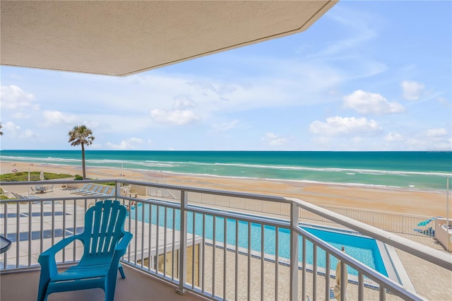 balcony featuring a water view and a view of the beach