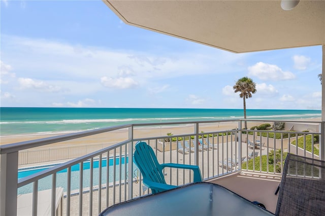 balcony with a water view and a beach view