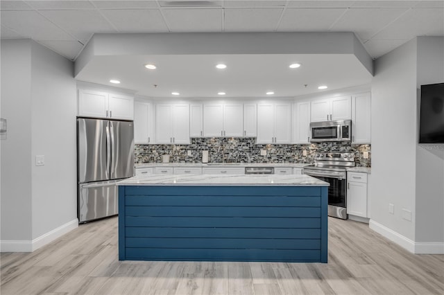 kitchen with decorative backsplash, light hardwood / wood-style flooring, stainless steel appliances, light stone countertops, and white cabinets