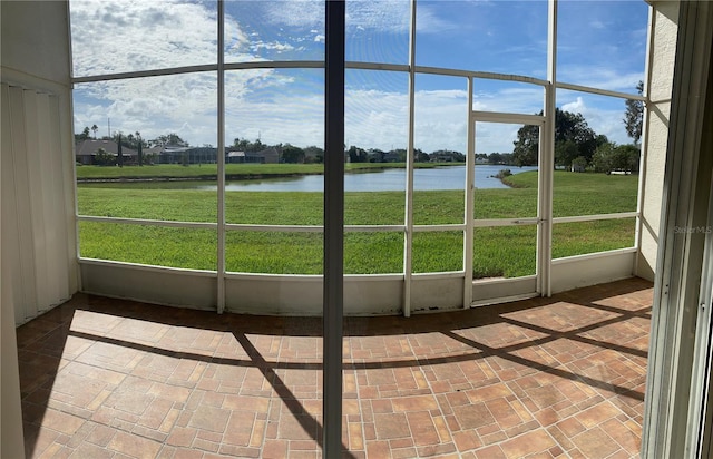 unfurnished sunroom featuring a water view