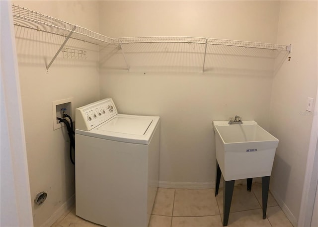 washroom with washer / clothes dryer, sink, and light tile patterned floors