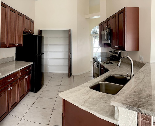 2688 Hawthorne Ln, Kissimmee, FL 34743 - kitchen with appliances with stainless steel finishes, a sink, a high ceiling, light tile patterned flooring, and baseboards