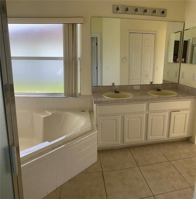 bathroom featuring vanity, tile patterned floors, and tiled tub