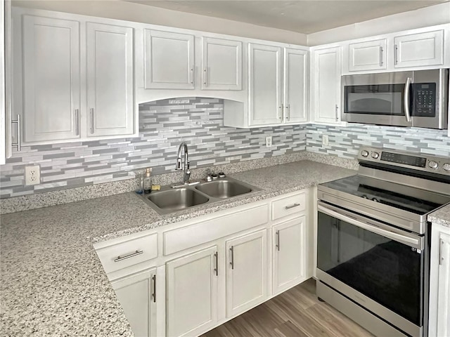 1904 Historic Goldsboro Blvd, Sanford, FL 32771 - kitchen featuring backsplash, stainless steel appliances, white cabinets, and a sink