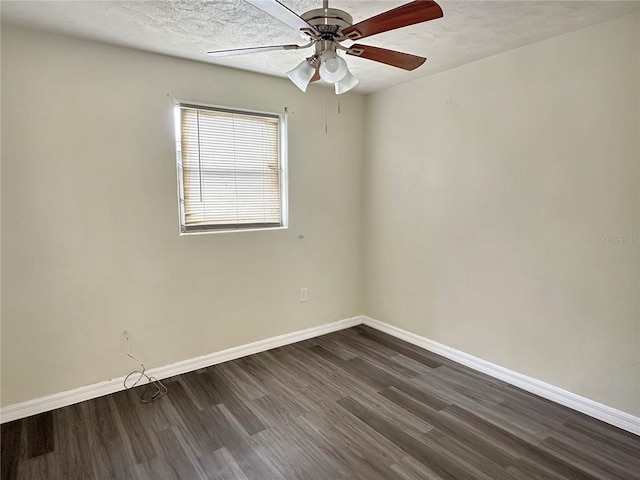 spare room featuring dark wood-type flooring, ceiling fan, and a textured ceiling